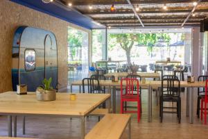 a restaurant with wooden tables and chairs and a refrigerator at Càmping Bellsol in Pineda de Mar