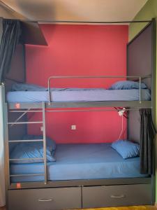 two bunk beds in a room with a red wall at Prishtina Center Hostel in Pristina