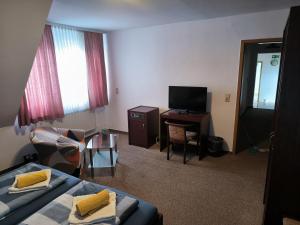 a hotel room with a bed and a television at Zimmer am Jüdenhof in Heilbad Heiligenstadt