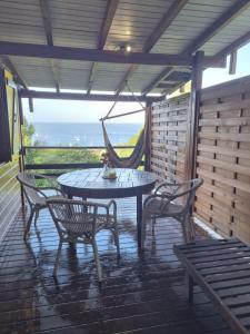 un tavolo e sedie su un patio con vista di Bungalow Jamaïque a Deshaies
