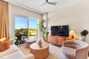 sala de estar con TV, sofá y sillas en Bocobay Aracari Condo Hotel en Palm-Eagle Beach