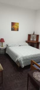 1 dormitorio con cama, lámpara y mesa en Departamento cerca del centro en Mar del Plata