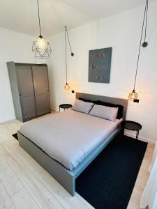 a bedroom with a bed with two tables and two lights at Design Moderno in Centro - Lainate- Rho Fiera in Lainate