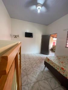 Habitación con cama y TV en la pared. en Suites Flor de Lis, en Pirenópolis