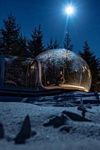 una persona en una cúpula en la nieve por la noche en Buubble Hotel - Ölvisholt, en Selfoss