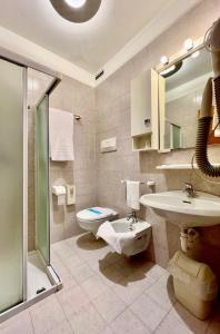 a bathroom with a toilet and a sink and a shower at Hotel Bella Venezia in Latisana