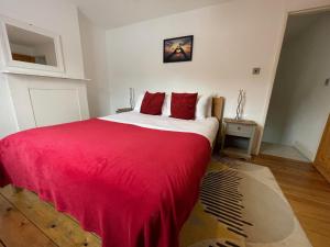 Un dormitorio con una cama grande con una manta roja. en The Pearl - Stylish 3 Bedrooms house in great central location, en Brighton & Hove