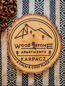 una señal de madera en un lateral de una pared en WoodStone Apartments Karpacz, en Karpacz