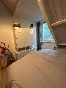 sypialnia z dużym łóżkiem i oknem w obiekcie Vakantiehuis BijSaar w mieście Noordwijk