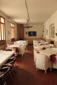 una sala da pranzo con tavoli e sedie bianchi di Hotel Rey Niño ad Ávila
