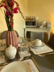 un tavolo con un vaso con dei fiori sopra di The Ashton Gate Mews a Bristol