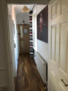 a hallway with a door and a painting on the wall at F2 STUDIO - 485sq Feet 4 Room - PERFECT for LONG STAY - FREE STREET PARKING - WASHER - NETFLIX - Welcome Tray 1 FREE Dog in Barry