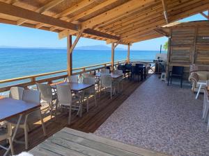 un restaurante en la playa con mesas y sillas en Assos Green Bungalow, en Ayvacık