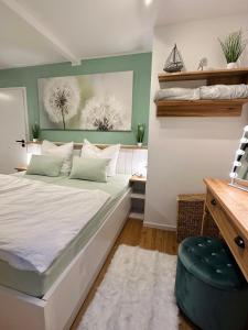 a bedroom with a white bed with a green wall at Ferienhaus Ella in Trautskirchen