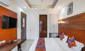 a bedroom with a bed and a flat screen tv at FabHotel Grace Inn in Gurgaon