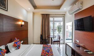 a hotel room with a bed and a table and a television at FabHotel Grace Inn in Gurgaon