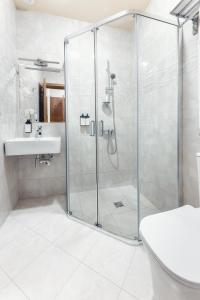 een badkamer met een glazen douche en een wastafel bij Park Hotel Tskaltubo - Balneo Resort in Tskaltubo
