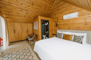 1 dormitorio con cama blanca y paredes de madera en Doors Urla Hotel & Bungalows en İzmir