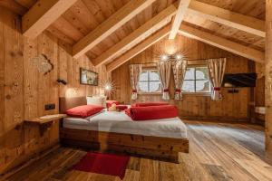 ein Schlafzimmer mit einem Bett in einem Holzzimmer in der Unterkunft FARM CHALET JUSCIARA in Abtei