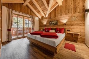 ein Schlafzimmer mit einem Bett in einem Zimmer mit Holzwänden in der Unterkunft FARM CHALET JUSCIARA in Abtei