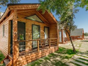a log cabin with a porch and a deck at Doors Urla Hotel & Bungalows in İzmir
