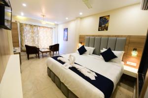 ein Schlafzimmer mit einem großen Bett, einem Tisch und Stühlen in der Unterkunft Puri Beach Resort in Puri