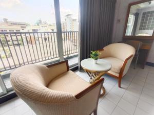 balcone con 2 sedie e tavolo con vista di OYO 75446 Travis Inthamara 49 a Bangkok