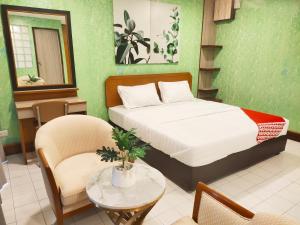 a bedroom with a bed and a table and chairs at OYO 75446 Travis Inthamara 49 in Bangkok