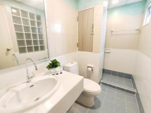 a white bathroom with a sink and a toilet at OYO 75446 Travis Inthamara 49 in Bangkok