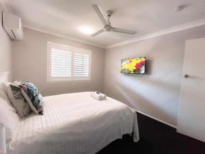 um quarto com uma cama e uma ventoinha de tecto em Rochedale South Business or Holiday like Home em Rochedale South