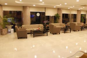 eine Lobby mit Stühlen und Sofas in einem Gebäude in der Unterkunft Plaza Home in Khobar