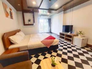 um quarto com uma cama e um piso em xadrez em OYO 75446 Travis Inthamara 49 em Bangkok