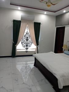 伊斯蘭堡的住宿－Edge of Islamabad Entrance，一间卧室设有一张床和一个大窗户