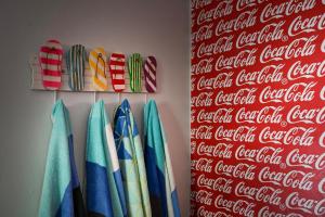 a group of surfboards hanging on a wall with a cocacola soda sign at Die Brandhuis Sleeps 4, One minute walk to the Beach! in Gordonʼs Bay