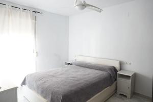 a white bedroom with a bed and a window at Gran casa ideal para familias in Atarfe