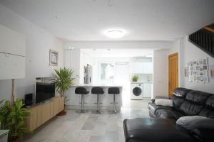 sala de estar con sofá y cocina en Gran casa ideal para familias en Atarfe