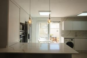 a kitchen with a white counter top and a table at Gran casa ideal para familias in Atarfe
