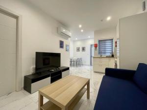 a living room with a blue couch and a table at Brooklyn Apartments Sliema in Sliema