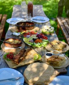 a wooden table with plates of food on it at Villa deluxe n'Bjeshkë in Dragash