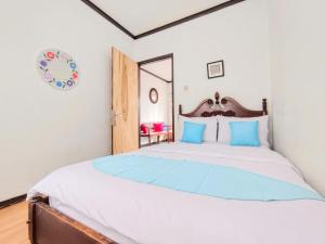 a bedroom with a large bed with blue pillows at Villa Cisarua Wulan in Brujul +15 photos