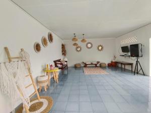 un soggiorno con pareti bianche e pavimento piastrellato di Villa Cisarua Wulan a Brujul