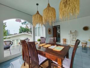 a dining room with a wooden table and chairs at Villa Cisarua Wulan in Brujul