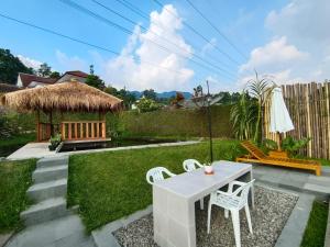 a small backyard with a table and chairs and a grass yard at Villa Cisarua Wulan in Brujul