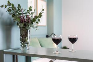 zwei Gläser Wein und eine Vase Blumen auf dem Tisch in der Unterkunft Moontels Mercado de Ruzafa in Valencia