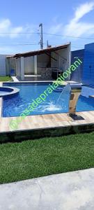 a swimming pool with a ramp in front of a building at Casa de praia giovani in Aracaju