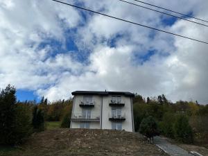 a white building with two balconies on top of a hill at Roomflacja in Wisła