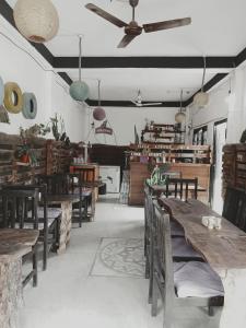 a restaurant with wooden tables and chairs and a ceiling fan at Hotel Holidays Inn - A Family Running Guest House in Meghauli