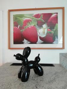 a statue of a dog in front of a picture of strawberries at Charmante Wohnung in Aalen