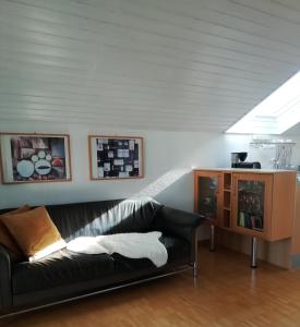 sala de estar con sofá negro y mesa en Charmante Wohnung, en Aalen