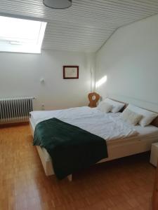 a bedroom with a large white bed with a window at Charmante Wohnung in Aalen